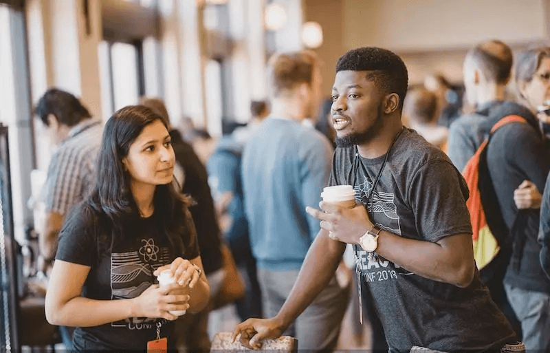 Developers connecting at a React community meetup